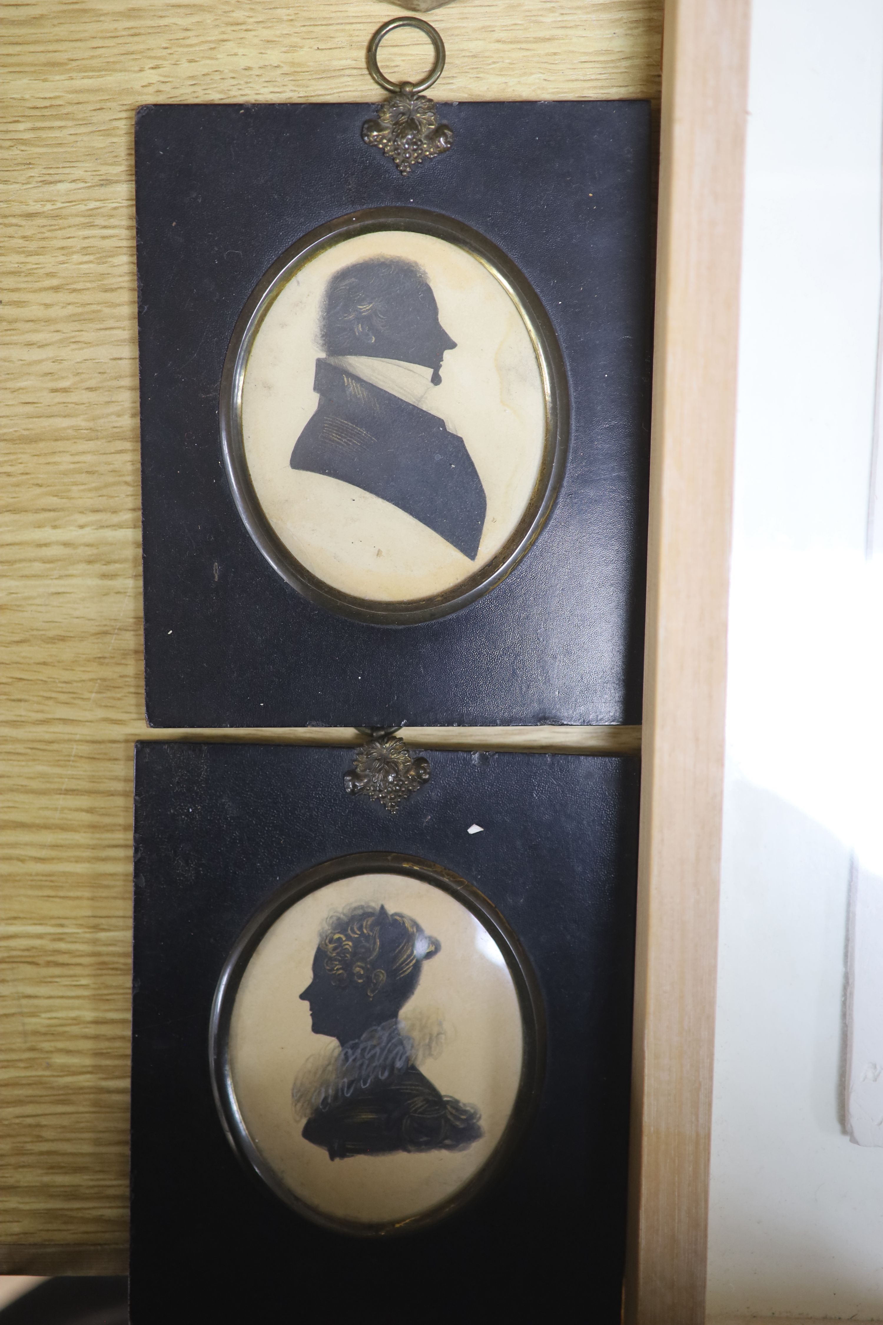 A pair of silhouettes, a plaster panel of a nude, indistinctly signed, and a plaster bust of a baby